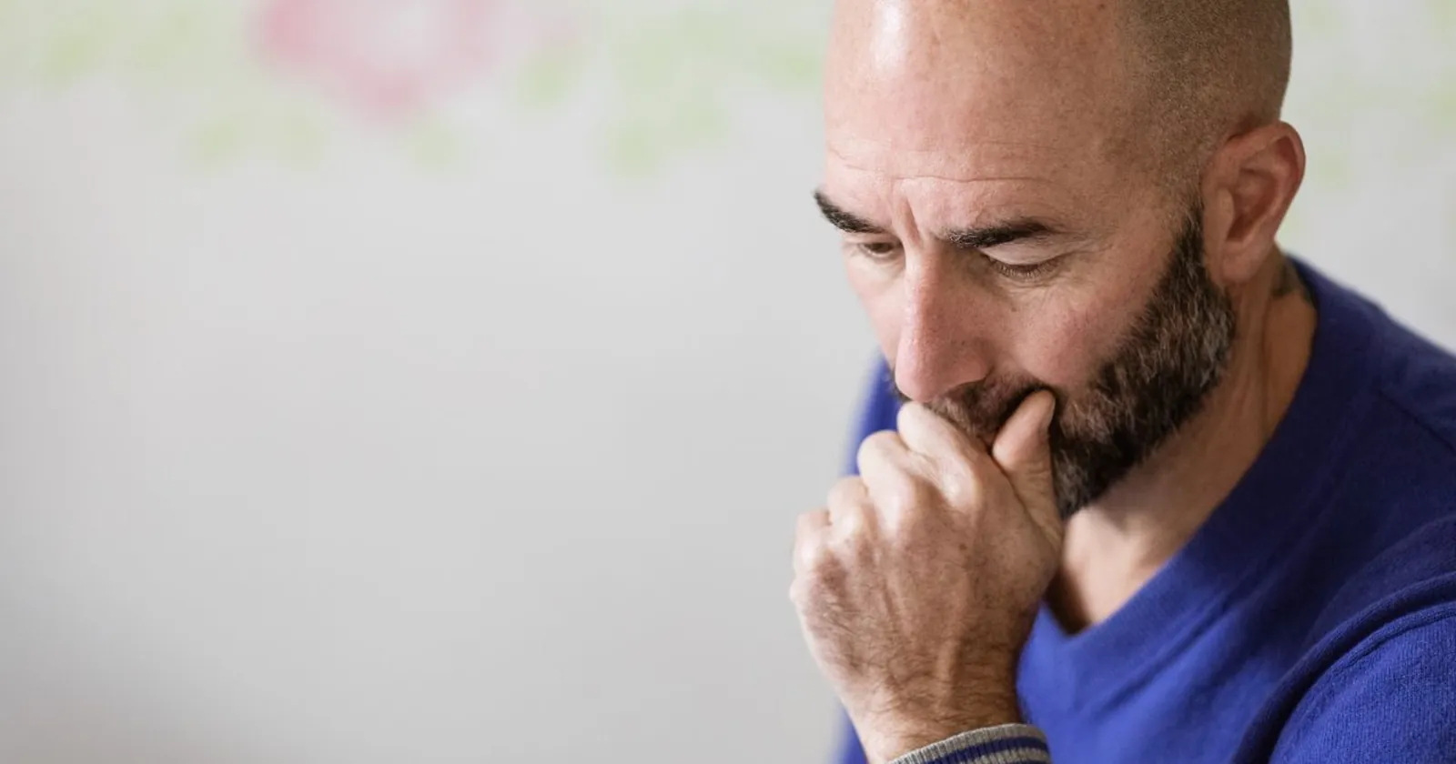 Cla Mosca im blauen Pullover, nachdenklich, die Hand am Kinn
