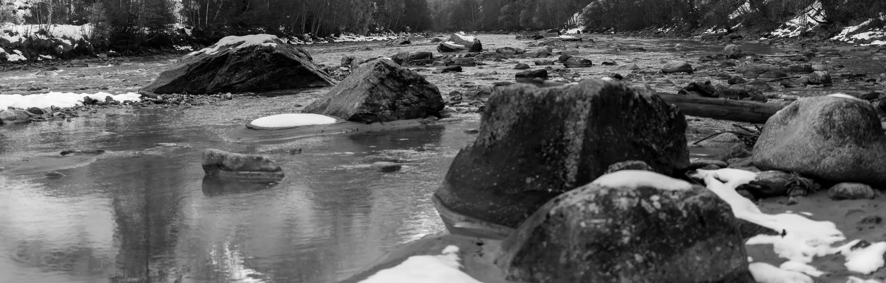 Der Inn im Unterengadin, Findlinge im flachen Wasser, Schnee auf den Steinen